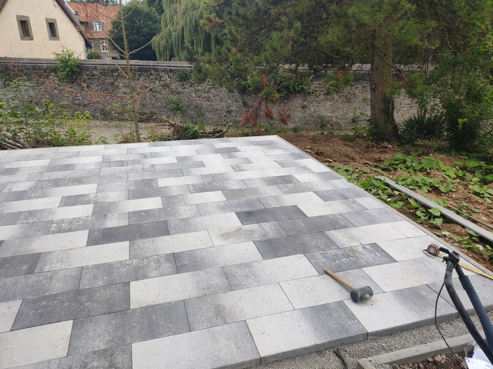 Fertig verlegte Terrasse aus hellen und dunklen Pflastersteinen